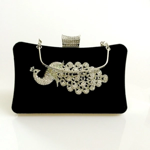 Detailed view of luxury black velvet evening bag featuring crystal peacock decoration