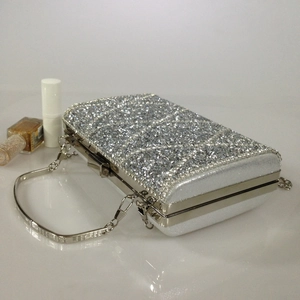Detail of silver rhinestone evening clutch bag with metal frame and thin chain strap