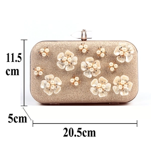 Detailed view of champagne glitter clutch with pearl floral design and dimensions labels