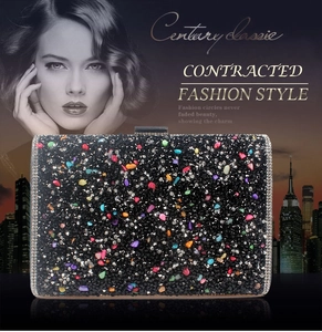 Close-up of black evening clutch bag with colorful rhinestones and gemstone accents
