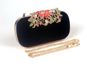 Close-up of colorful crystal floral rhinestones on black velvet evening clutch bag