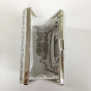 Detailed interior of silver sequin evening clutch with metal chain and white lining