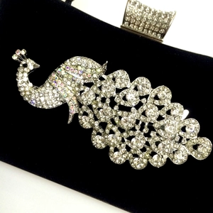 Detailed view of peacock-shaped velvet evening bag with sparkling crystal rhinestone inlay