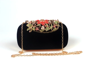 Close-up of luxury velvet clutch with multicolor gemstone floral clasp and gold chain