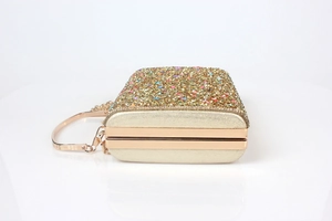 Detailed side view of golden shell evening clutch bag with colorful glitter and metal chain
