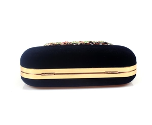 Detail of black velvet clutch bag with gold trim and multi-color crystal rhinestone clasp