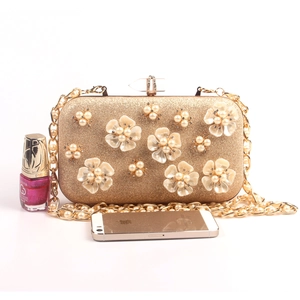 Detail of pearl flower clutch evening bag with gold chain and champagne sequin finish