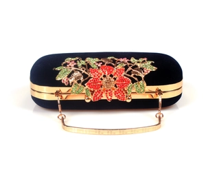 Detail of black velvet clutch bag featuring colorful crystal floral leaf decoration
