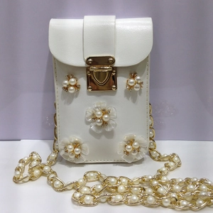 Detailansicht der weißen Handytasche mit Blumen-Perlen-Deko und goldener Kette