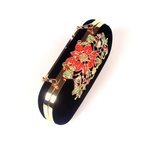 Detail of velvet evening clutch with vibrant rhinestone floral pattern and gold metal frame
