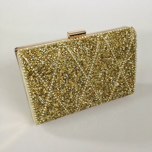 Close-up of luxury evening clutch bag featuring yellow and white crystals in geometric pattern