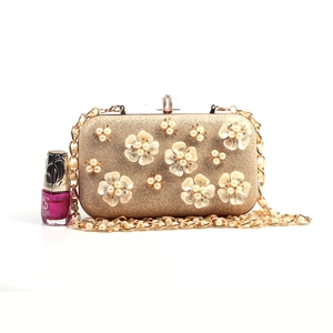 Detail of gold floral clutch bag with 3D petals, pearls and rhinestone clasp