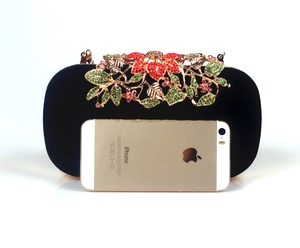 Detail of black velvet evening bag featuring crystal encrusted leaf clasp and rhinestones