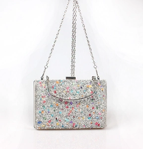 Detail of evening clutch bag showing silver glitter finish and colorful rhinestone accents