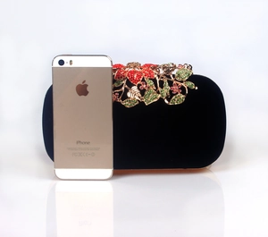 Macro detail of velvet evening clutch with rhinestone encrusted floral metal clasp