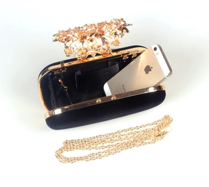 Detail of velvet evening bag with gold floral handle and interior storage capacity