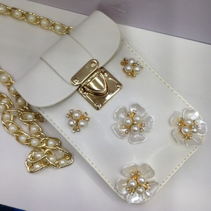 Nahaufnahme der weißen Leder-Handytasche mit 3D-Perlenblumen und goldener Kette