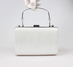 Detail of silver sparkling evening clutch with curved metal handle and metallic closure