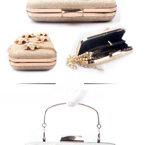 Detail of evening clutch featuring metallic flowers, pearls, and a gold chain strap