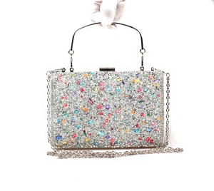 Detail of silver glitter evening bag featuring colorful rhinestones and metal handle