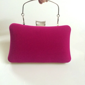 Detail of rose red velvet evening clutch with silver round handle and beaded closure