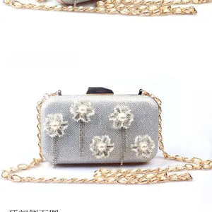 Detail of silver sequin evening bag with pearl floral clusters and rhinestone tassels