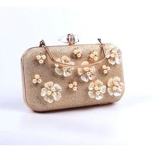 Detailed view of bridal clutch bag with 3D floral accents, pearls and gold hardware