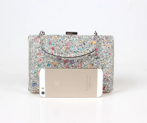 Sparkly rhinestone evening clutch size comparison with a phone for scale and storage detail