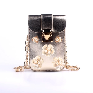 Detail der goldenen Handy-Tasche mit Perlenblütenblättern und Strasssteinen