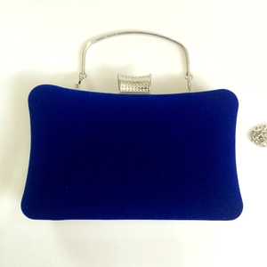 Detail of dark blue velvet evening clutch with silver handle and rhinestone clasp