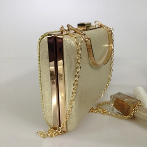 Side view of champagne gold glitter evening clutch with rhinestone trim and chain strap