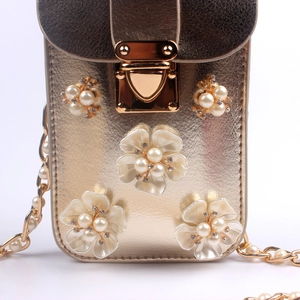 Nahaufnahme der goldenen Mini-Tasche mit 3D-Blumen, Perlen und glänzenden Kristallen