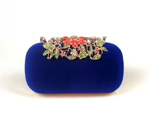Detail of royal blue velvet evening clutch with ornate floral rhinestone metal clasp
