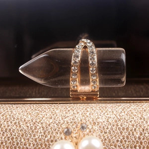 Macro shot of gold arch ring with pave crystal diamonds on sparkling gold surface