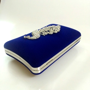 Macro detail of royal blue velvet evening clutch with silver rhinestone peacock decor