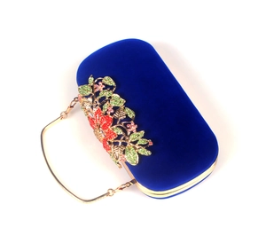 Close-up of royal blue velvet evening bag with crystal flower and leaf ornaments