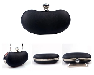 Detail view of black evening clutch with crystal clasp and silver chain strap