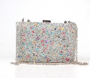 Macro shot of silver clutch bag with colorful rhinestones and metal chain strap