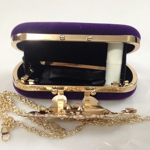 Detail view of purple velvet evening clutch with chain and interior space for lipstick