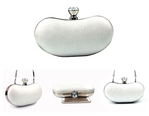 Detail of white evening clutch featuring a large crystal clasp and detachable metal chain