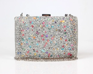 Close-up of sparkling silver rhinestones and colorful gemstones on the evening clutch bag