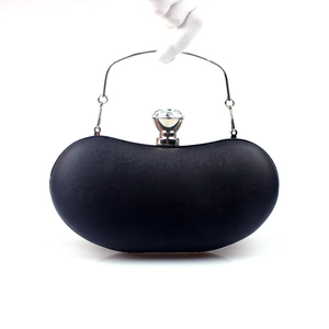 Detail of black faux leather clutch bag with silver ring handle and crystal clasp
