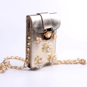 Detailansicht der goldenen Handytasche mit Perlenblumen und einer Gliederkette