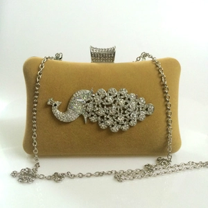 Detailed view of the sparkling crystal peacock ornament on velvet evening clutch bag