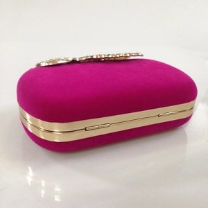 Detail of rose red velvet evening clutch with crystal butterfly clasp and gold frame