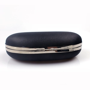 Detail of the black leather clutch bag featuring a crosshatch texture and silver metal frame
