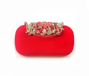 Detail of red velvet evening bag with gold floral clasp and colorful crystals