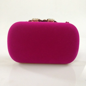 Detail of rose red velvet evening clutch with gold crystal clasp for formal banquet