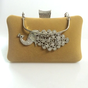 Detail of velvet evening clutch with ornate rhinestone peacock ornament and metal frame