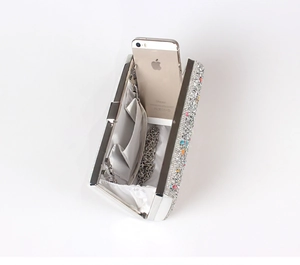 Detail of evening clutch interior with satin lining, side pocket, and silver chain strap